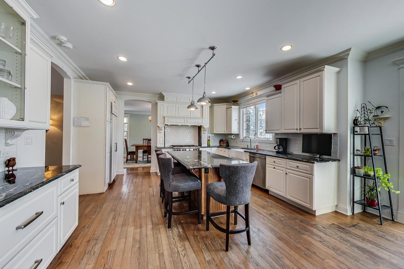819 Redbud Lane Wilmette, IL 60091 - Photo 13 of 70 a kitchen with a dining table chairs wooden floor cabinets and appliances
