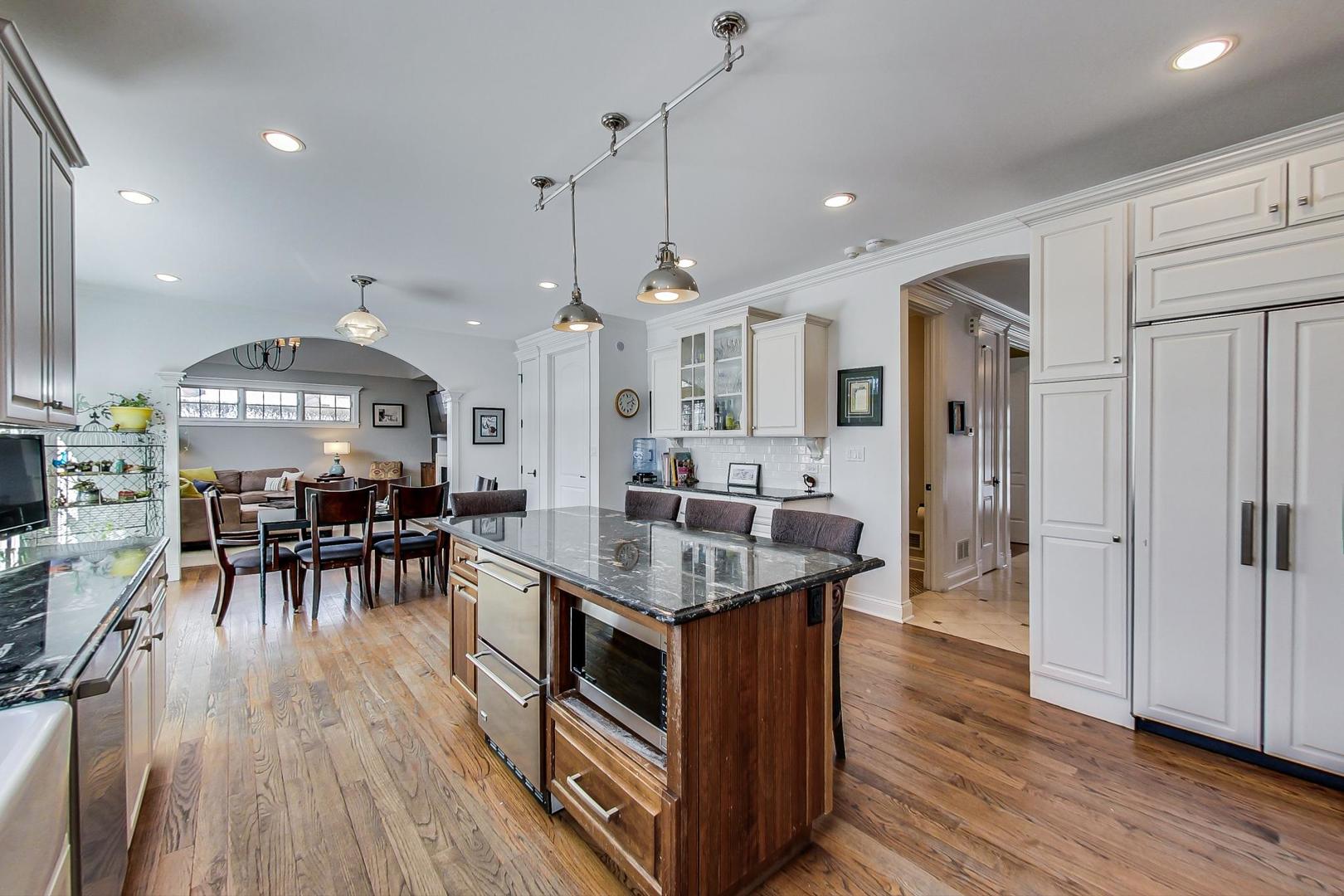 819 Redbud Lane Wilmette, IL 60091 - Photo 15 of 70 a kitchen with stainless steel appliances granite countertop a stove oven a refrigerator a dining table and chairs with wooden floor
