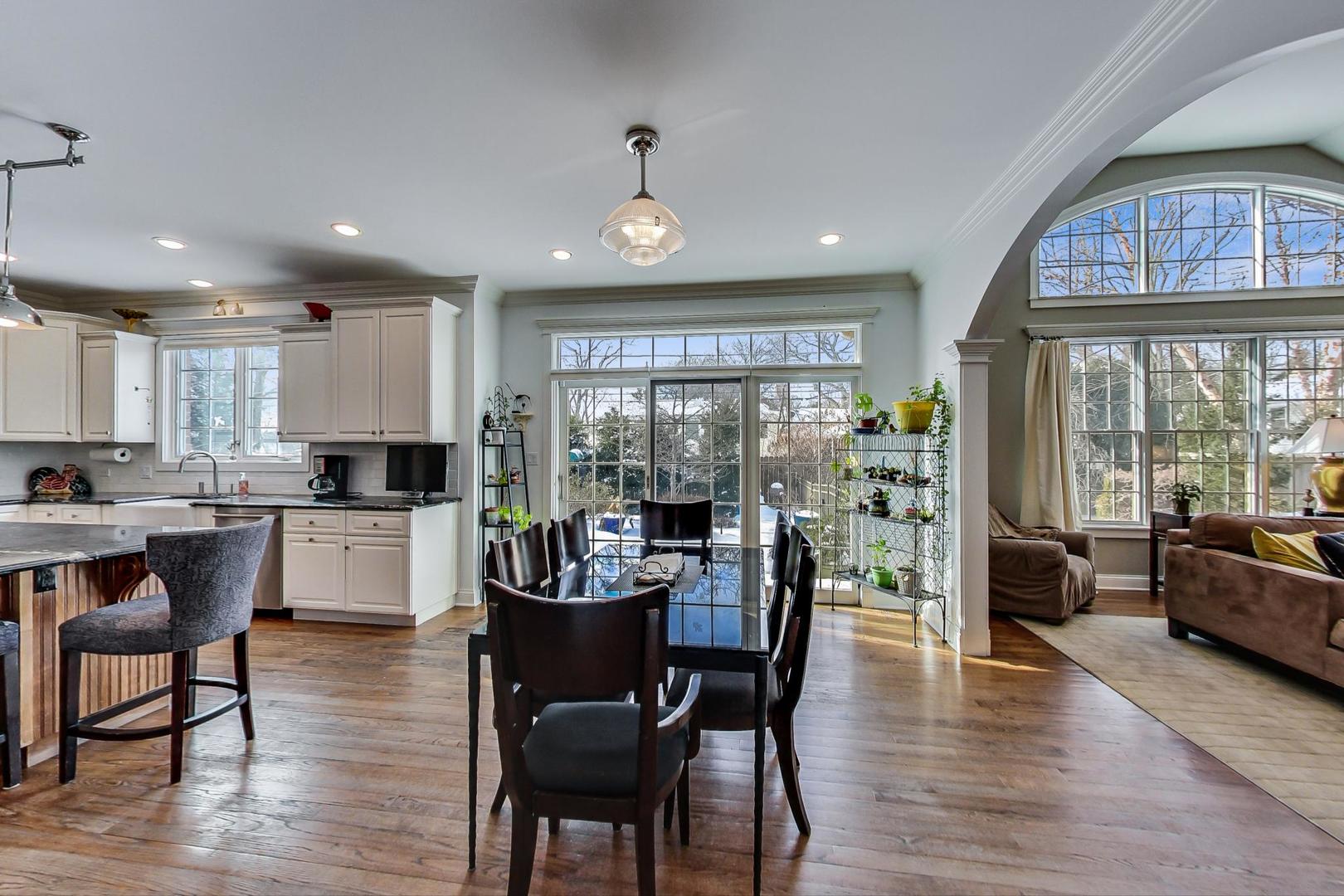 819 Redbud Lane Wilmette, IL 60091 - Photo 17 of 70 a kitchen with stainless steel appliances granite countertop a stove a refrigerator a kitchen island a dining table and chairs with wooden floor