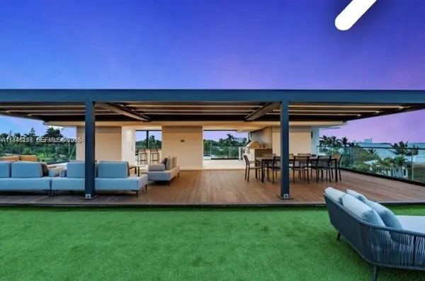 a living room with furniture and floor to ceiling windows