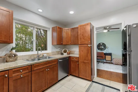 a kitchen with stainless steel appliances granite countertop wooden cabinets a stove top oven a sink and dishwasher