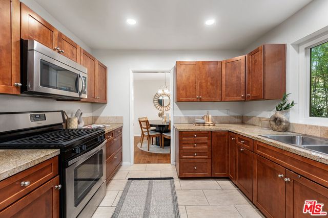 a kitchen with stainless steel appliances granite countertop a refrigerator stove and microwave