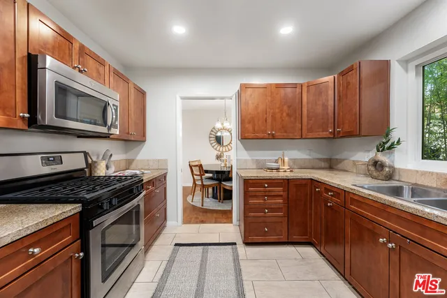 a kitchen with stainless steel appliances granite countertop a refrigerator stove and microwave