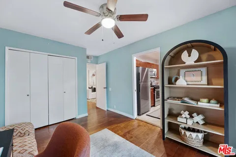 a view of a yard with plants and large trees
