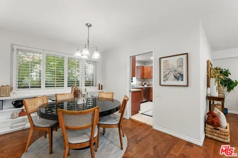 a dining room with furniture a chandelier and wooden floor