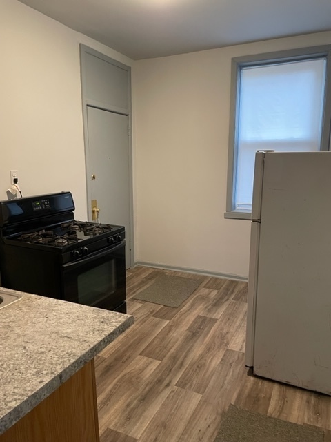 1237 West Marquette Road, Unit 1W Chicago, IL 60636 - Photo 2 of 9 a kitchen with a stove and a refrigerator