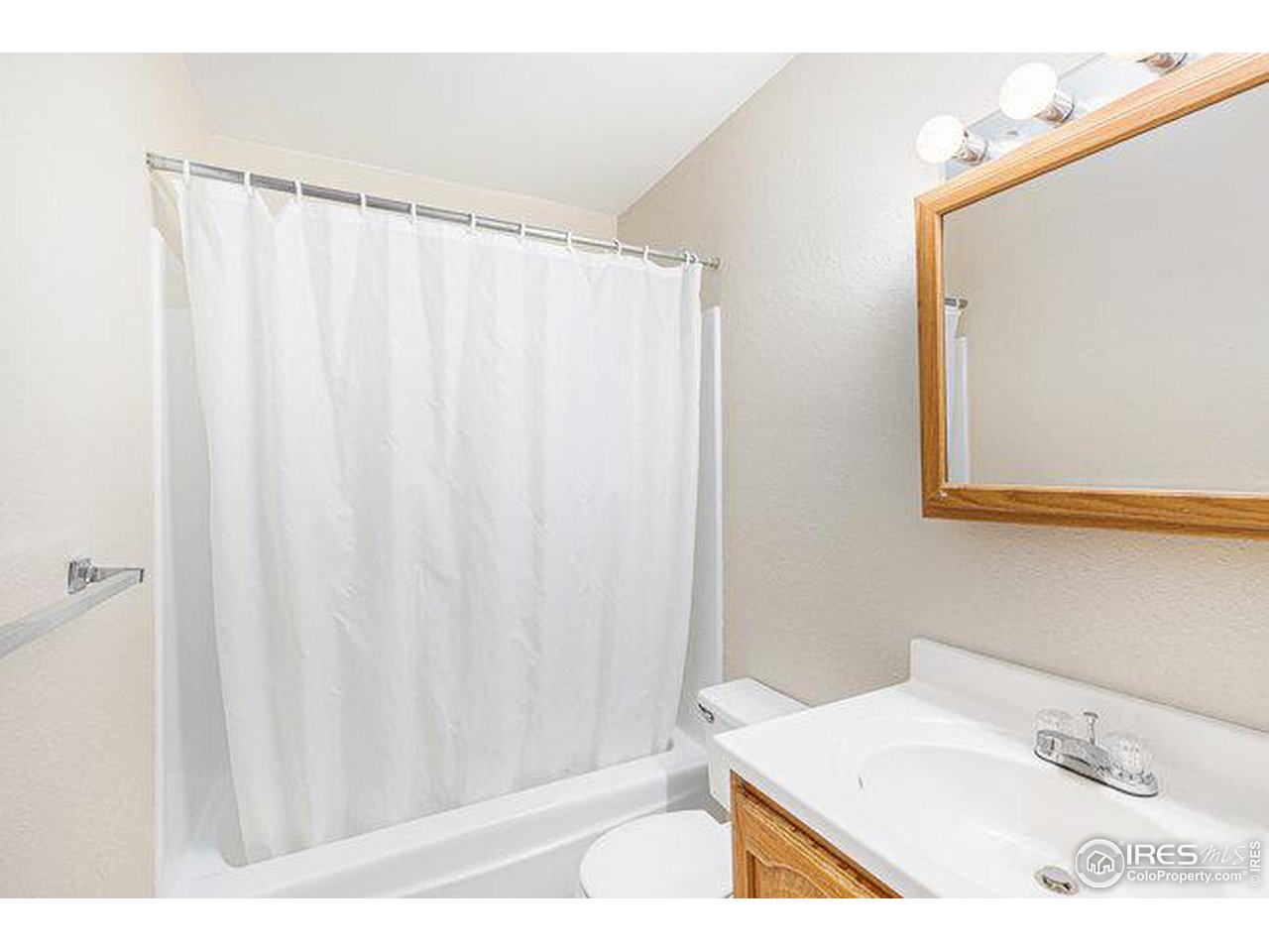 806 Stone Mountain Drive, Unit 103 Windsor, CO 80550 - Photo 7 of 10 a bathroom with a sink and a mirror