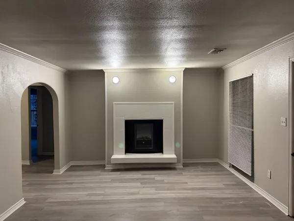 an empty room with wooden floor and fireplace