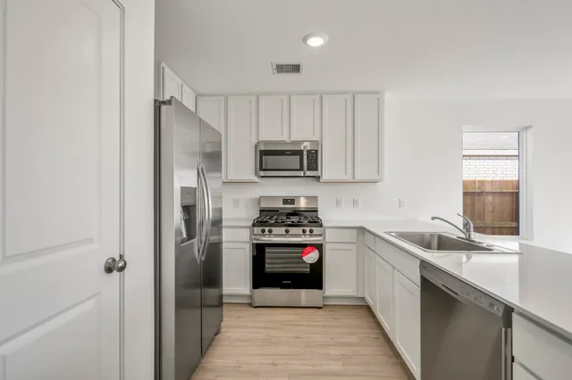 a kitchen with a sink stove and refrigerator