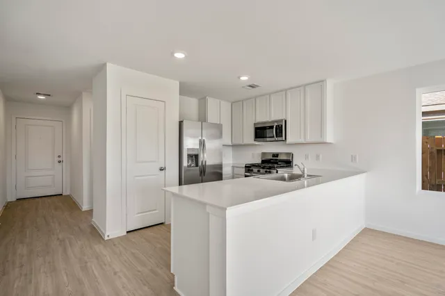 a kitchen with refrigerator a microwave and cabinets