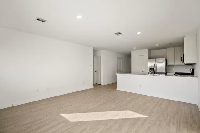 a view of kitchen with kitchen island microwave and wooden floor