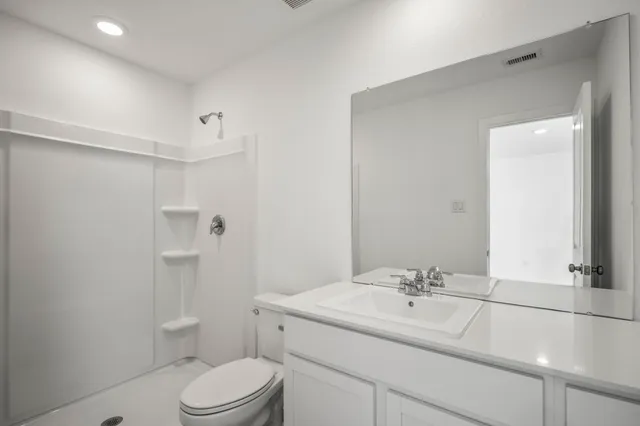 a bathroom with a sink toilet vanity and shower