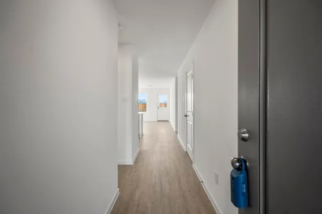 a view of a hallway with wooden floor and staircase