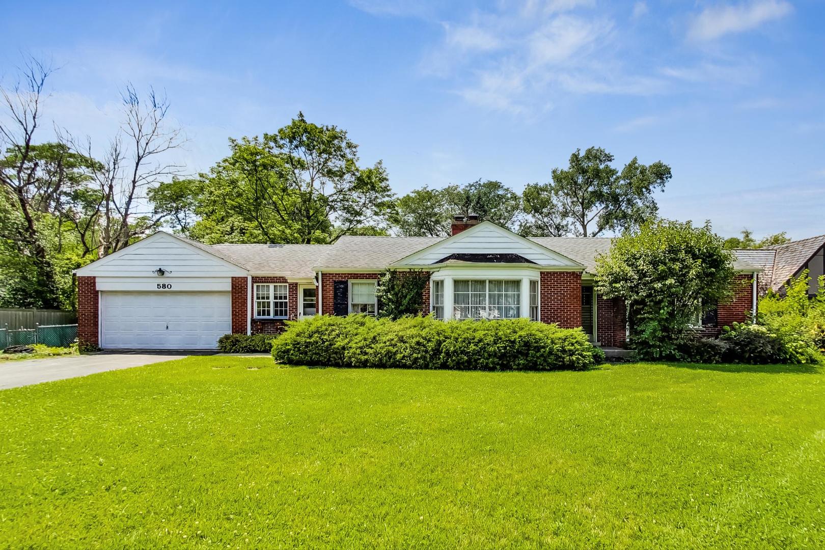 580 North Happ Road Northfield, IL 60093 - Photo 1 of 49 a front view of a house with a yard and garage