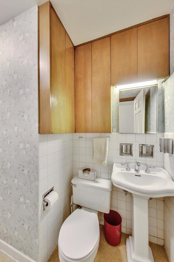 580 North Happ Road Northfield, IL 60093 - Photo 17 of 49 a bathroom with a toilet sink and mirror