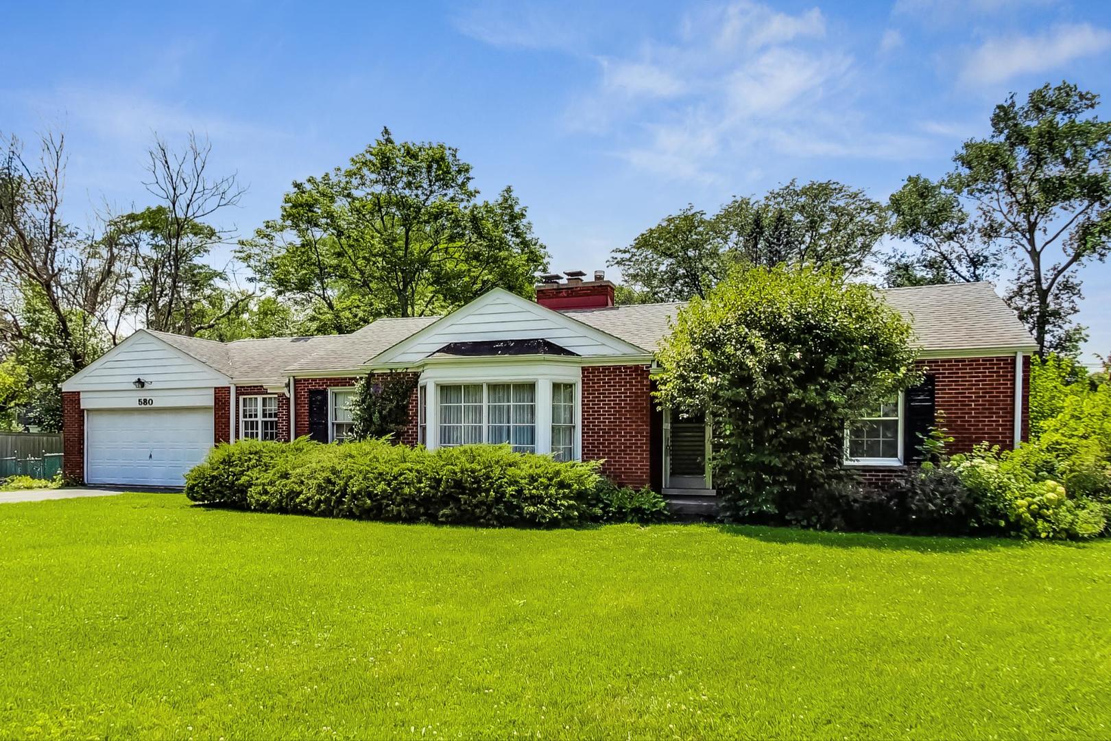580 North Happ Road Northfield, IL 60093 - Photo 2 of 49 a front view of a house with a garden