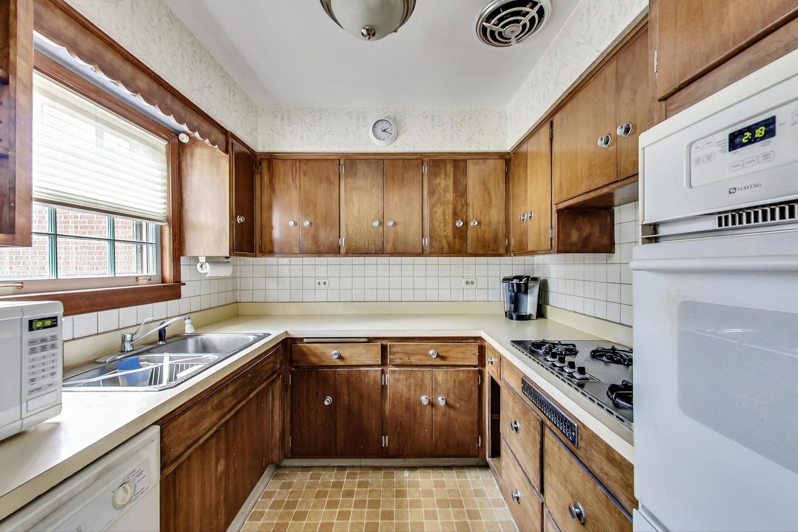 580 North Happ Road Northfield, IL 60093 - Photo 6 of 49 a kitchen with a sink a stove cabinets and a window