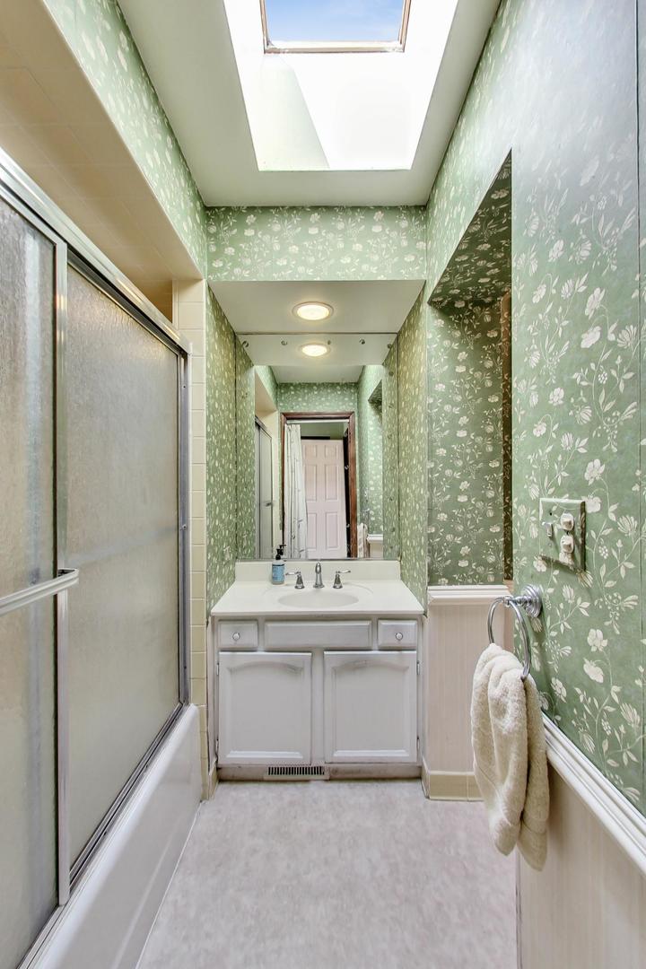 580 North Happ Road Northfield, IL 60093 - Photo 9 of 49 a bathroom with a sink mirror and a bathtub