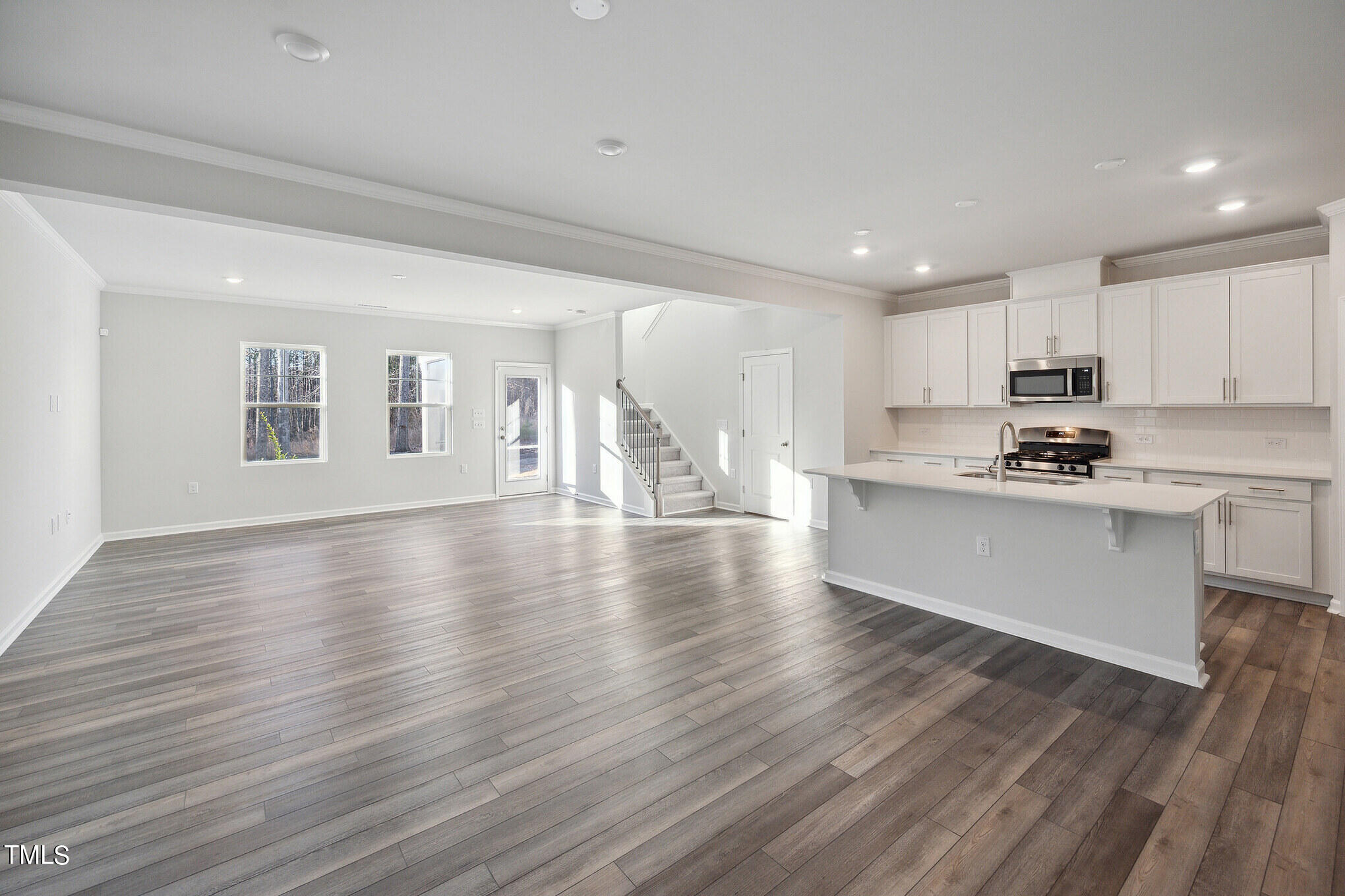 532 Hanover Shore Lane Raleigh, NC 27610 - Photo 2 of 31 a view of a kitchen with a sink and dishwasher a stove top oven with wooden floor