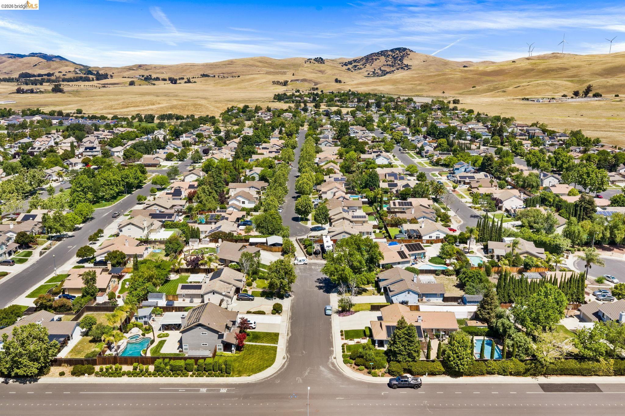 1186 El Rio Court Livermore, CA 94551 - Photo 54 of 60 Aerial perspective of a residential neighborhood featuring numerous single-family homes with pitched roofs, mature trees lining streets, and some properties with private swimming pools