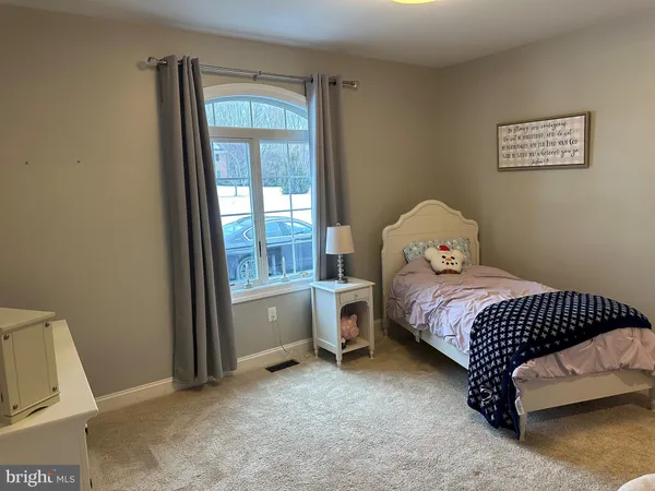 a bedroom with a bed and a dresser next to a window