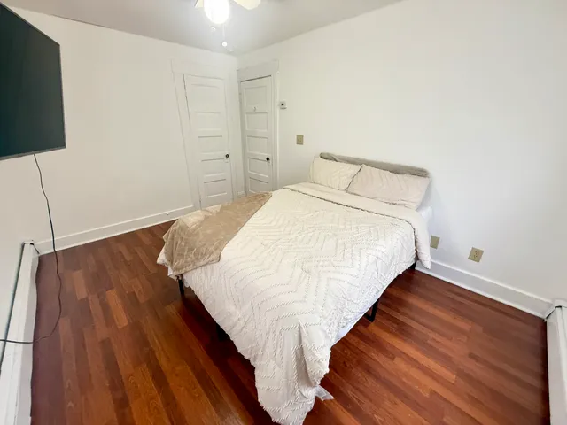 a bed sitting in a bedroom and table chair