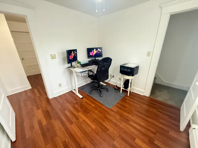 a view of a workspace with furniture and wooden floor