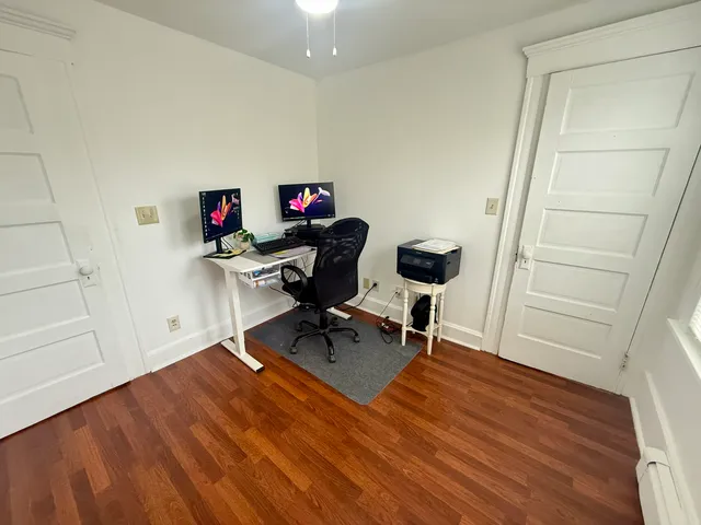 a view of a workspace with furniture and wooden floor