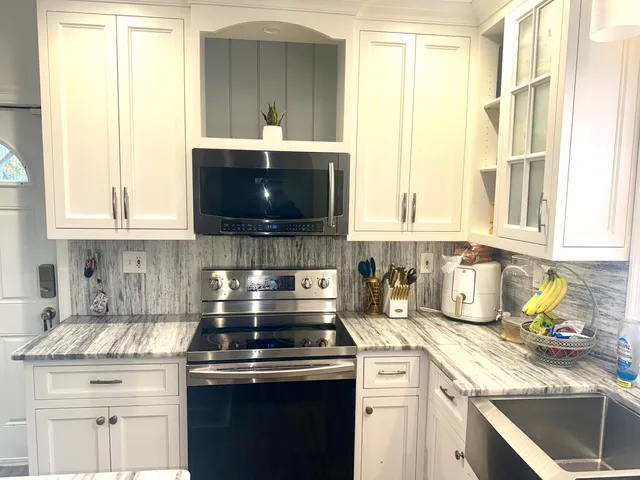 a kitchen with stainless steel appliances a stove a sink and a microwave