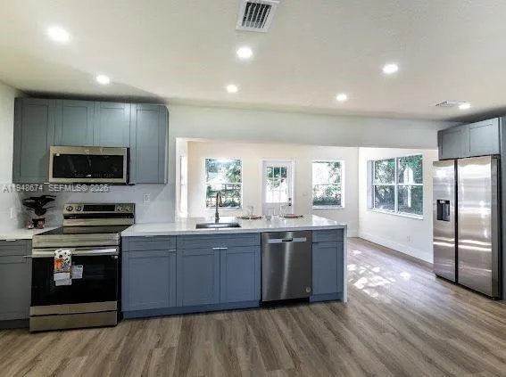 a large kitchen with stainless steel appliances granite countertop a stove and a sink