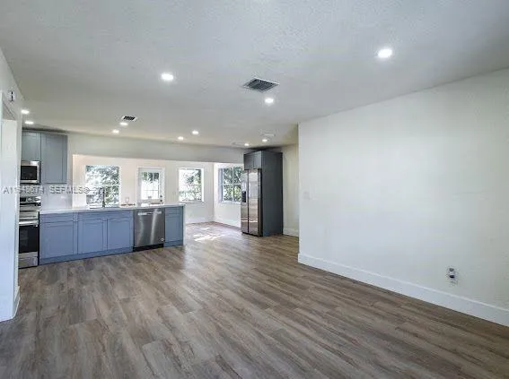 a large kitchen with a wooden floor and large window