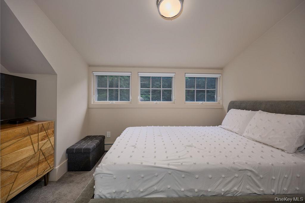 24 Acoma Road Tuxedo Park, NY 10987 - Photo 24 of 44 a bedroom with a bed and a flat tv screen