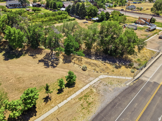 365 North Main Street Fillmore, UT 84631 - Photo 37 of 51 Expansive vacant lot featuring mature trees, a sidewalk border, and direct road frontage