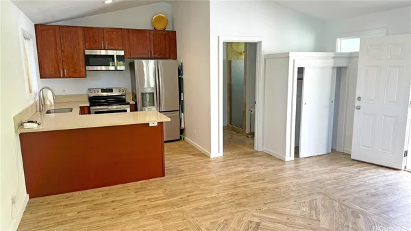 a kitchen with stainless steel appliances granite countertop a refrigerator a stove and a sink