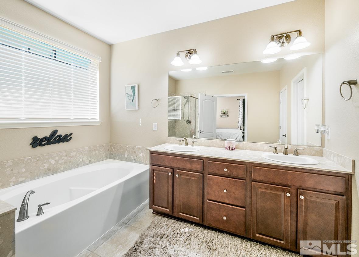 10250 Mott Drive Reno, NV 89521 - Photo 10 of 20 a bathroom with a tub double sink window and mirror
