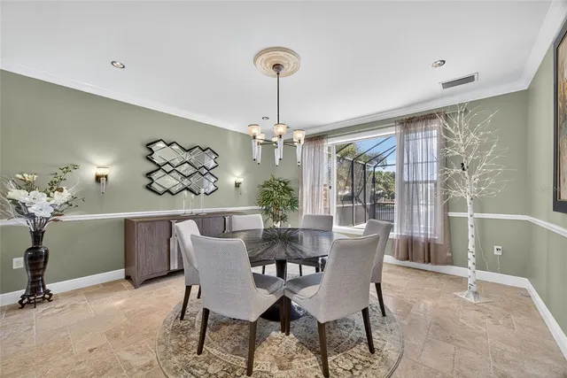 a kitchen with stainless steel appliances granite countertop a stove top oven a sink a dining table and chairs