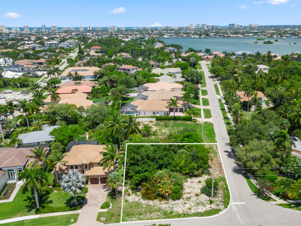 an aerial view of residential houses with outdoor space and trees