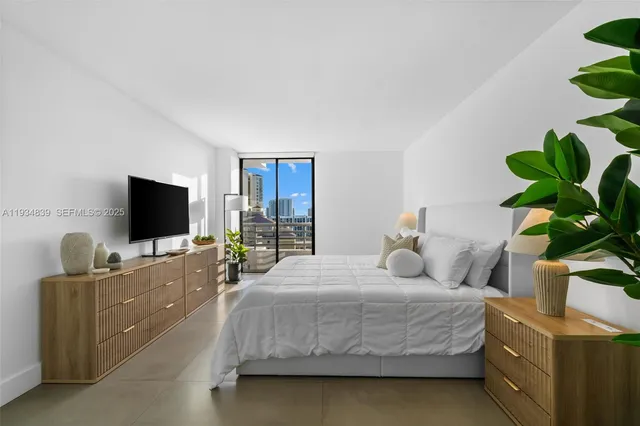 a bedroom with a bed and a flat screen tv