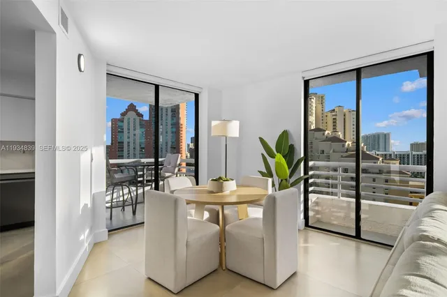 a dining room with furniture and a floor to ceiling window