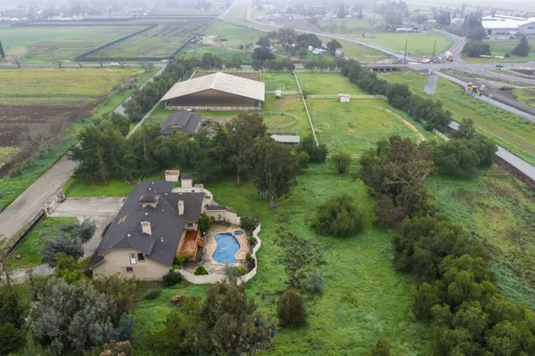 an aerial view of a house with a yard and outdoor seating
