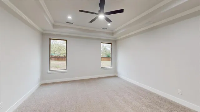 en empty room with windows and ceiling fan