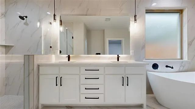 a bathroom with a double vanity sink mirror and bathtub