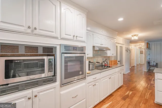 a kitchen with stainless steel appliances white cabinets and white appliances