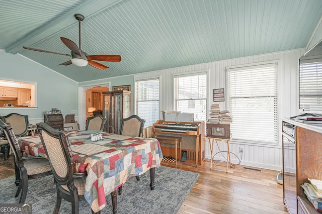 a bedroom with a bed a desk and chair with wooden floor