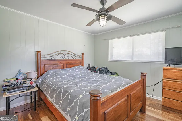 a bedroom with a bed and wooden floor