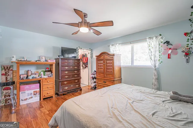 a bedroom with a bed and a wooden floor
