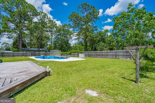 a view of a backyard with swimming pool