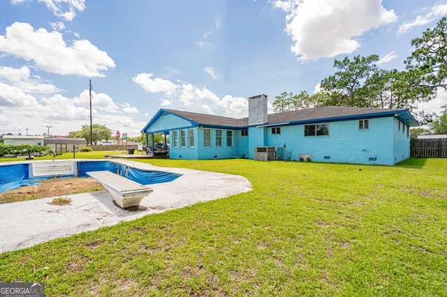a view of an house with swimming pool and yard