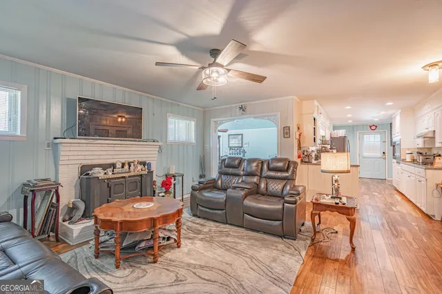 a living room with furniture a fireplace and wooden floor
