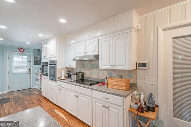 a kitchen with stainless steel appliances granite countertop a sink stove and cabinets